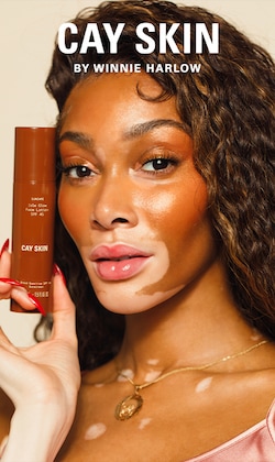 Cay Skin. By Winnie Harlow. Image of Winnie holding product. 